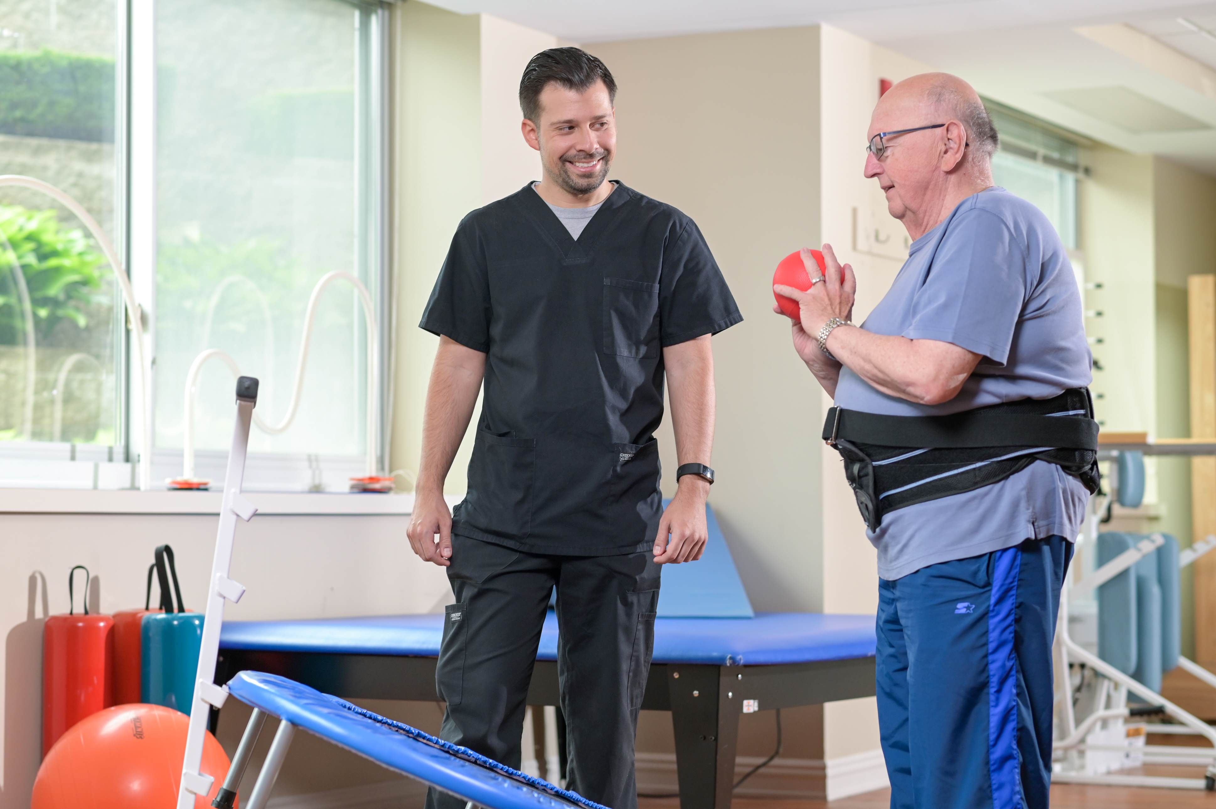 senior male working with physical therapist